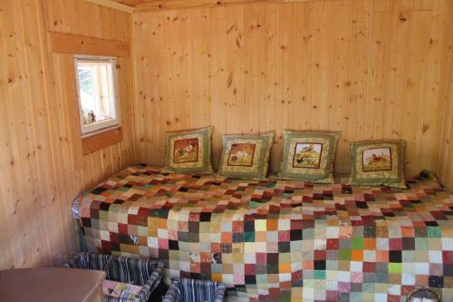 ein Schlafzimmer mit einem Bett mit vier Bildern darauf in der Unterkunft Metsäpirtti in Kolinkylä