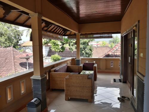 an outdoor patio with couches and a fireplace at Gede Homestay in Lovina