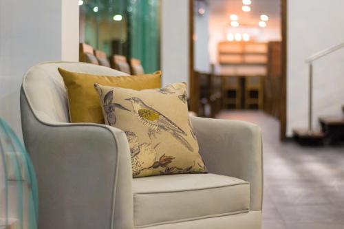 a chair with pillows on it in a room at KABAH Cancun Hotel Boutique in Cancún