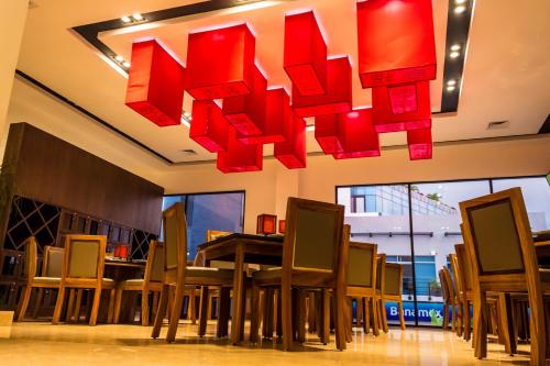 a restaurant with tables and chairs under red lights at KABAH Cancun Hotel Boutique in Cancún
