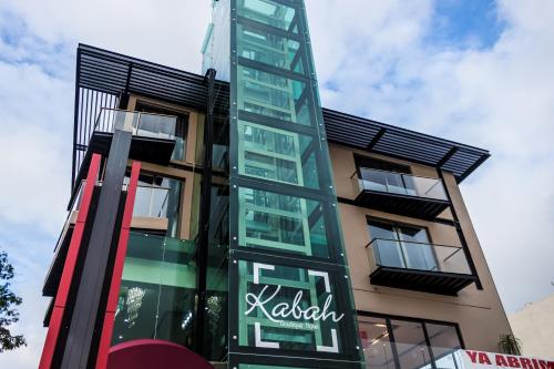 a tall glass building with a sign on it at KABAH Cancun Hotel Boutique in Cancún