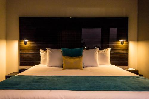 a bedroom with a large bed with white pillows at KABAH Cancun Hotel Boutique in Cancún
