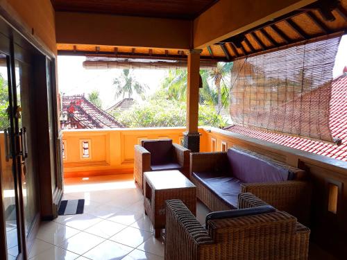 a room with two chairs and a table and a balcony at Gede Homestay in Lovina