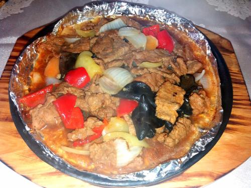 a dish of food with meat and vegetables on a table at Hotel & Restaurant Great Wall - Airport in Sarajevo