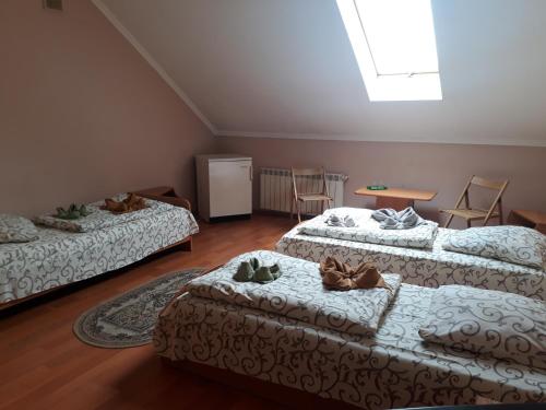 ムカチェヴォにあるApollonのベッド3台、テーブル、椅子が備わる客室です。