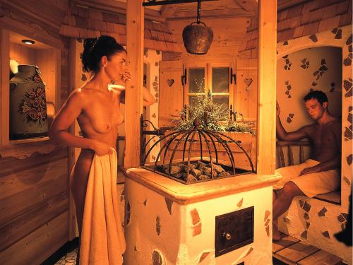 a woman standing in a room with a bird cage at Alpenhotel Tirolerhof in Neustift im Stubaital