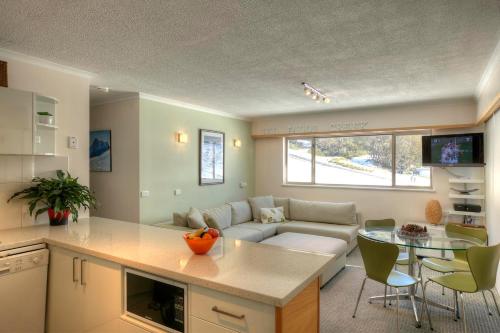 cocina y sala de estar con sofá y mesa en Alpine View Apartments, en Falls Creek