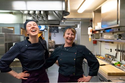 two women are standing in a kitchen at Vollan Gjestestue in Nordkjosbotn