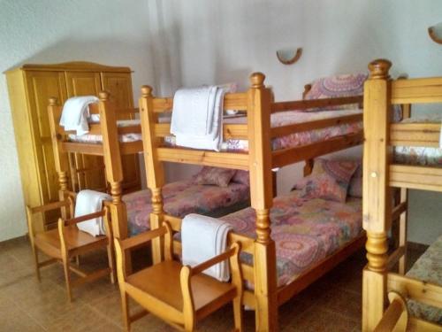 a room with bunk beds with a table and chairs at Magina Dream La Guardia Turismo Rural in La Guardia de Jaén
