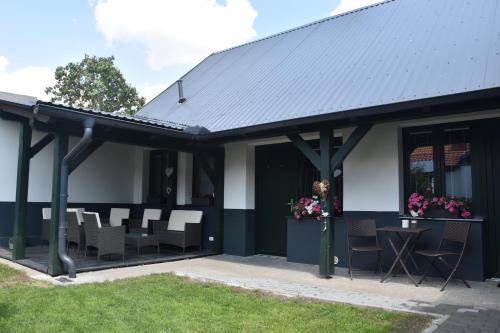 a black and white building with chairs and a table at Na Útesu in Jindřichŭv Hradec