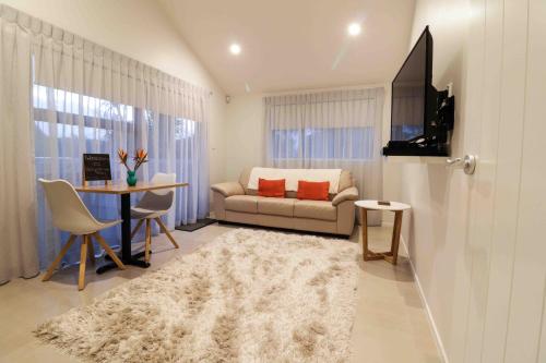 uma sala de estar com um sofá e uma mesa em Halfmoon Bay Apartment em Auckland