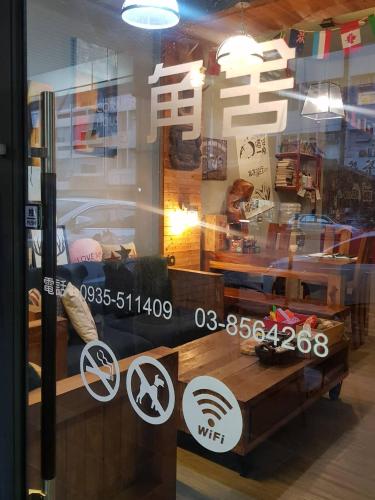 a window of a store with signs on it at 角舍背包客棧 -近火車站 in Hualien City