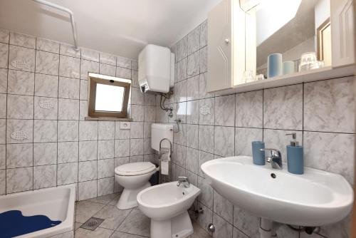 een witte badkamer met een wastafel en een toilet bij Apartment Lorena in Kaštelir