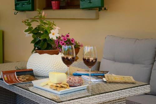 a table with two glasses of wine and cheese at Villa Le Facezie B&B in Terranuova Bracciolini