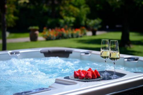 two glasses of wine and strawberries in a hot tub at Villa Le Facezie B&B in Terranuova Bracciolini