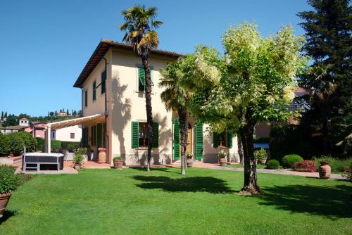 a house with a palm tree in the yard at Villa Le Facezie B&B in Terranuova Bracciolini