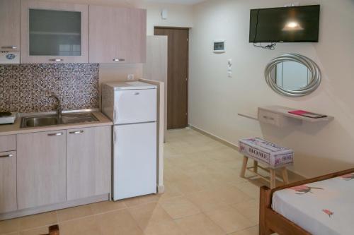 a kitchen with a white refrigerator and a sink at Zachos in Olympic Beach