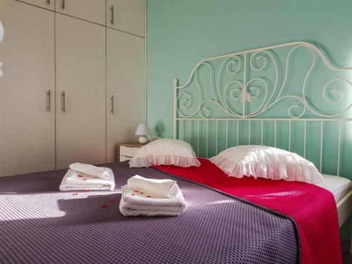 sypialnia z fioletowym łóżkiem i ręcznikami w obiekcie Marianos Apartments w mieście Kisamos