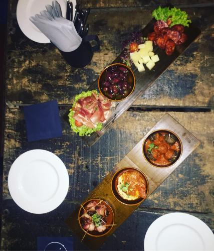 a table with plates and bowls of food on it at Hafen 17 Hotel Küche Bar in Kehl am Rhein