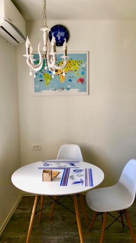 a white dining room table with two chairs and a chandelier at Luxury Villa Minerva Gardens in Split