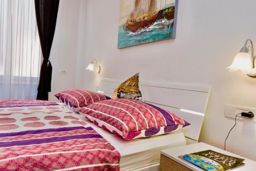 a bedroom with two beds with pink and purple pillows at Luxury Villa Minerva Gardens in Split