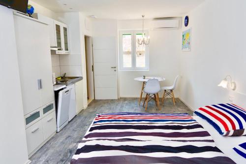 a small kitchen with a table and a bed in a room at Luxury Villa Minerva Gardens in Split