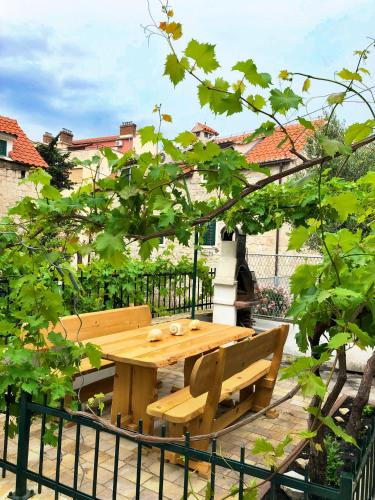 a wooden table and a bench in a garden at Luxury Villa Minerva Gardens in Split