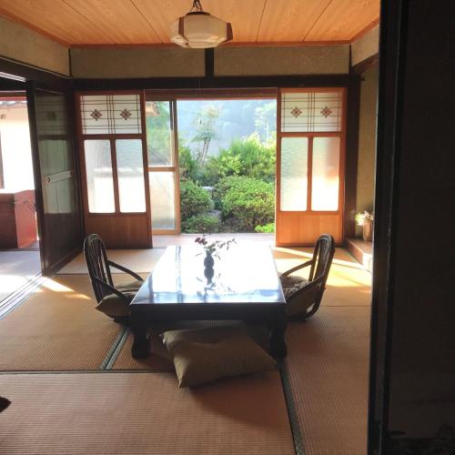 a dining room with a glass table and chairs at Yakuno House in Fukuchiyama