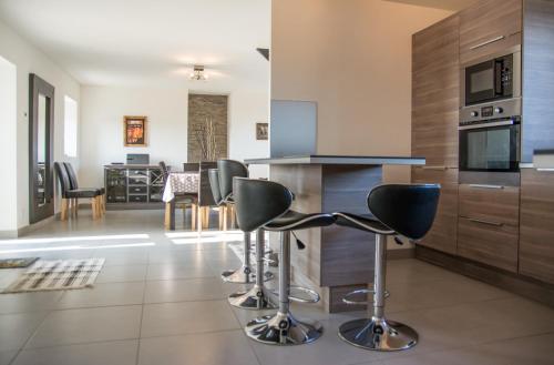 une cuisine avec un comptoir et des tabourets dans une pièce dans l'établissement Cap sur Pen ar Valy à Plougoulm, à Plougoulm