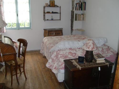 a bedroom with a bed and a table with a lamp at Moulin du Pont d'Alzon in Uzès