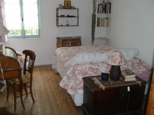 Un dormitorio con una cama y una mesa con una lámpara. en Moulin du Pont d'Alzon, en Uzès