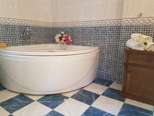 a bathroom with a tub with a vase of flowers at Villa Avra in Poros