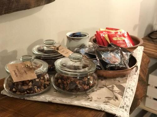 a table with four glass jars of food on it at le Piagge in Viterbo