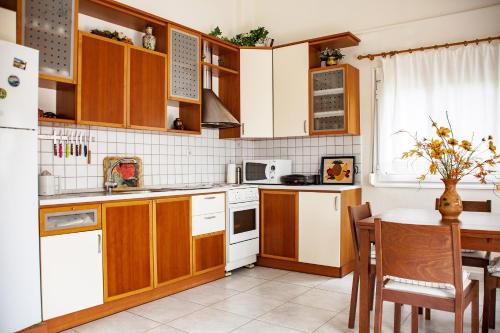 a kitchen with wooden cabinets and a table at K Residences in Elaiokhórion