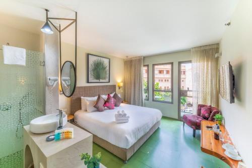 a hotel room with a bed, table and a mirror at Margosa Boutique Hotel Tel-Aviv Jaffa in Tel Aviv