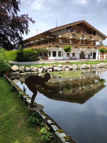 a man standing on a skateboard in front of a pond at Hotel Garni Eder in Gmund am Tegernsee