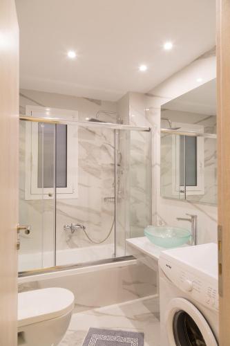 a bathroom with a shower and a toilet and a sink at Laura Beach House in Alykes