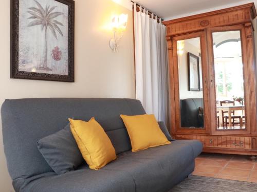 a living room with a couch with two yellow pillows at Lo Rastelié in Suze-la-Rousse