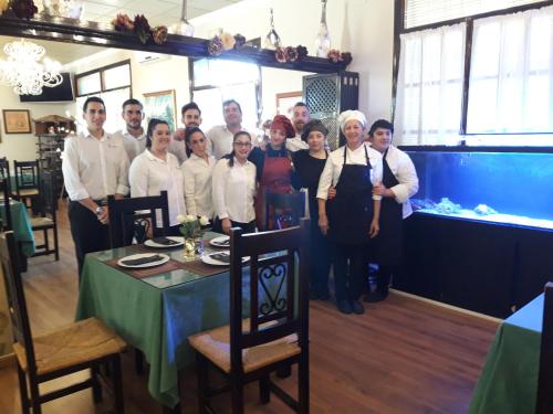 a group of people posing for a picture in a restaurant at Hostal Hispalis in Gandul