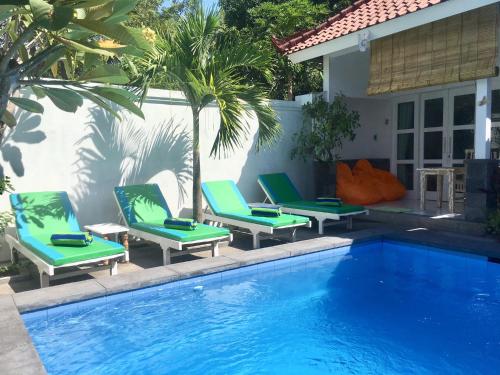 a group of chairs sitting next to a swimming pool at Narayana Homestay in Amed