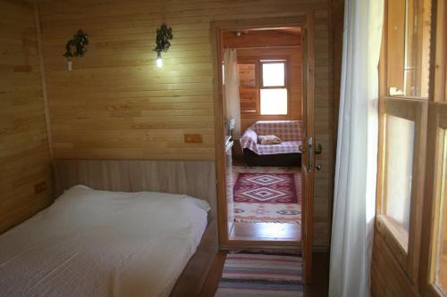 a small room with a bed in a wooden cabin at Naz Apartlari Cirali in Cıralı