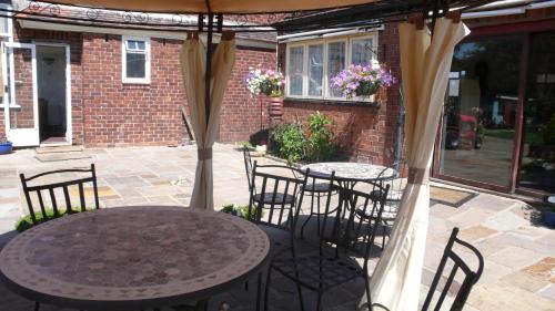 a patio with a table and chairs under an umbrella at Acorn Guest House in Hull in Hull