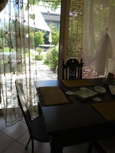 a dining room table and chairs in front of a window at La Serra in Murlo