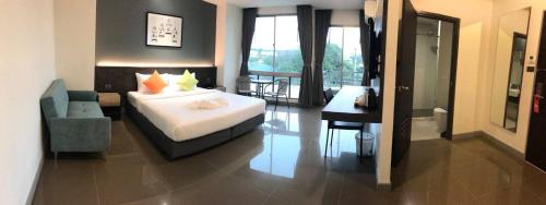 a hotel room with a bed and a desk and a bedroom at Clover Hotel Hatyai in Hat Yai