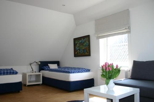 アルテンキルヒェンにあるBlue House Rügenのベッドルーム1室(ベッド1台、ソファ、テーブル付)