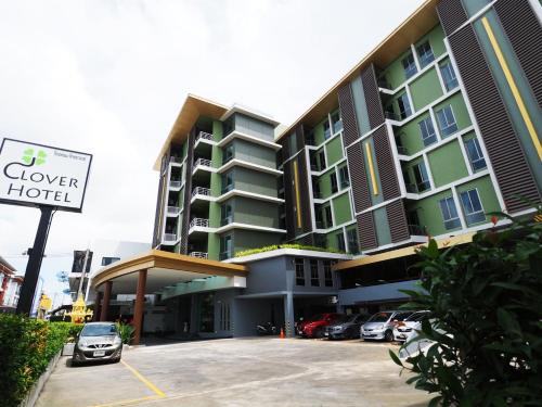 a building with a car parked in a parking lot at Clover Hotel Hatyai in Hat Yai