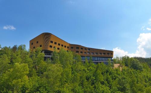 a building on top of a hill with trees at Tarcin Forest Resort & Spa Sarajevo - MGallery Collection in Tarčin