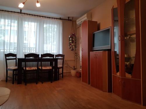 a living room with a dining room table and a television at Apartment Georgi Baev in Burgas