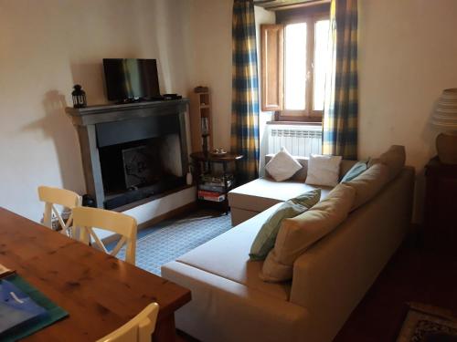 Una sala de estar con un sofá y una chimenea. en Casa Webb, en Bagni di Lucca