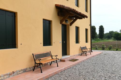 two benches sitting in front of a building at Ca dei Ciossi in Concordia Sagittaria